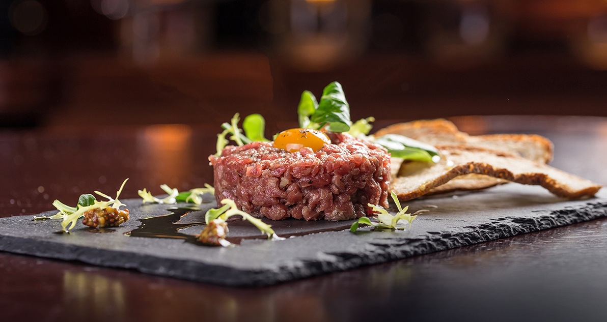Well presented meat dish with herbs and bread sticks at The Kingsbury Hotel