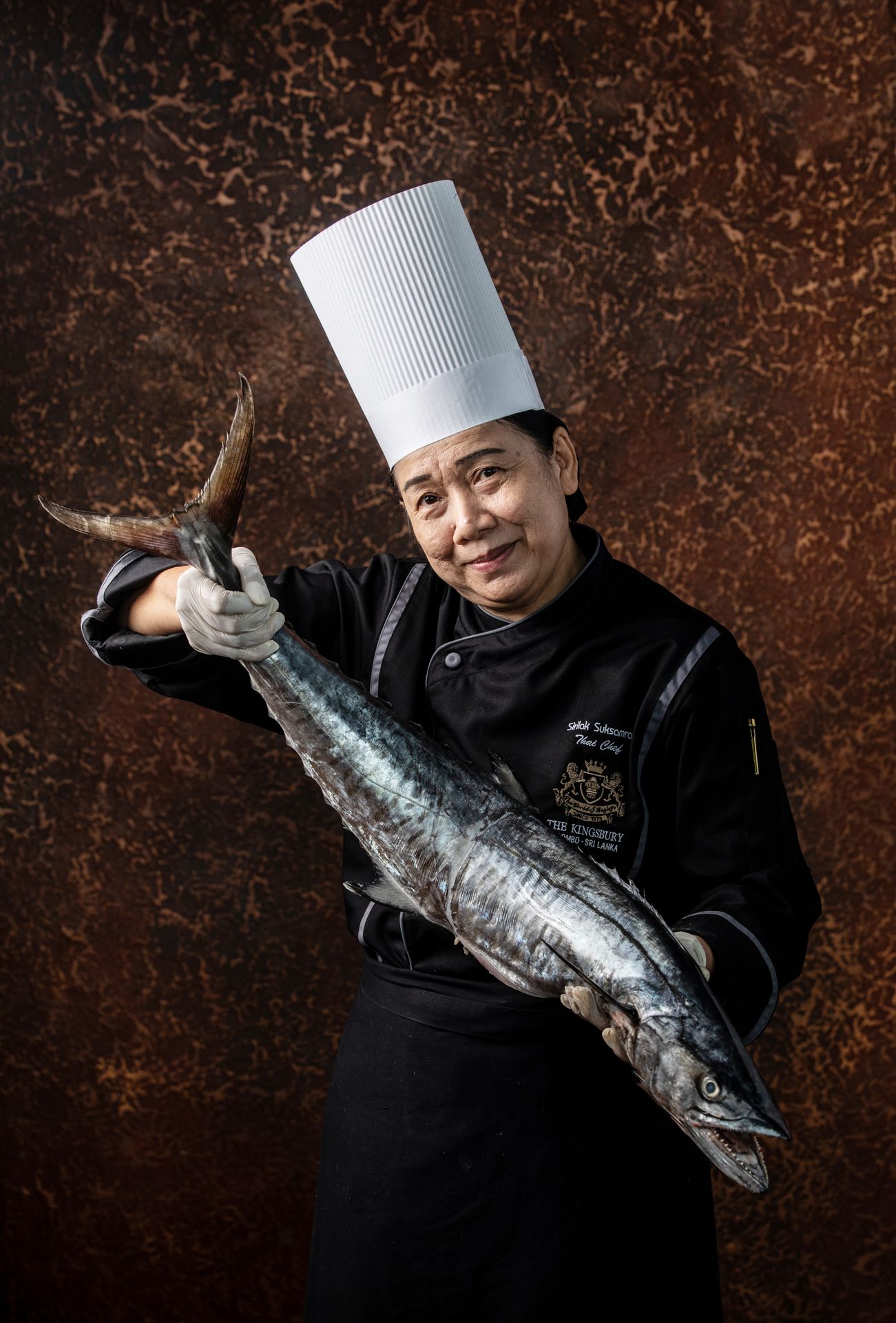 Chef holding a large fish with both hands at The Kingsbury Hotel