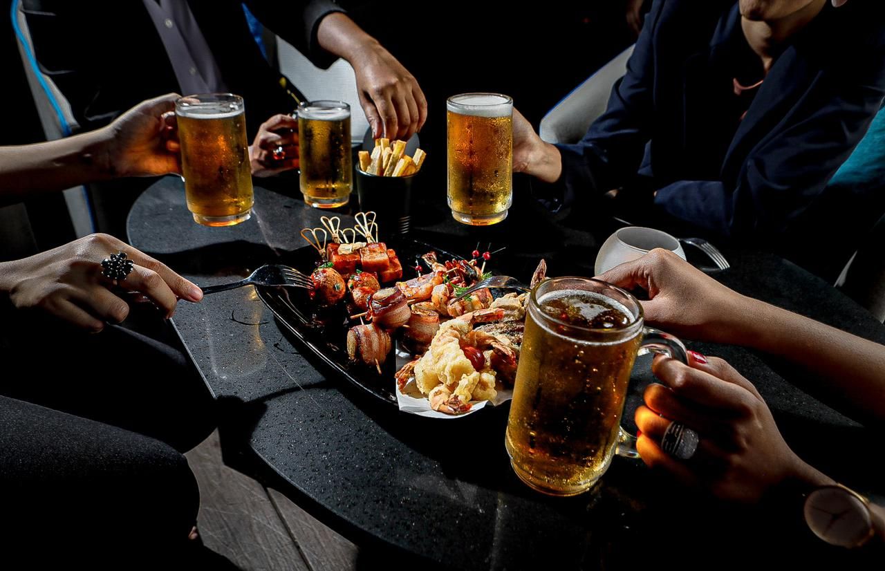 Guys enjoying beer with bar snacks at The Kingsbury Hotel