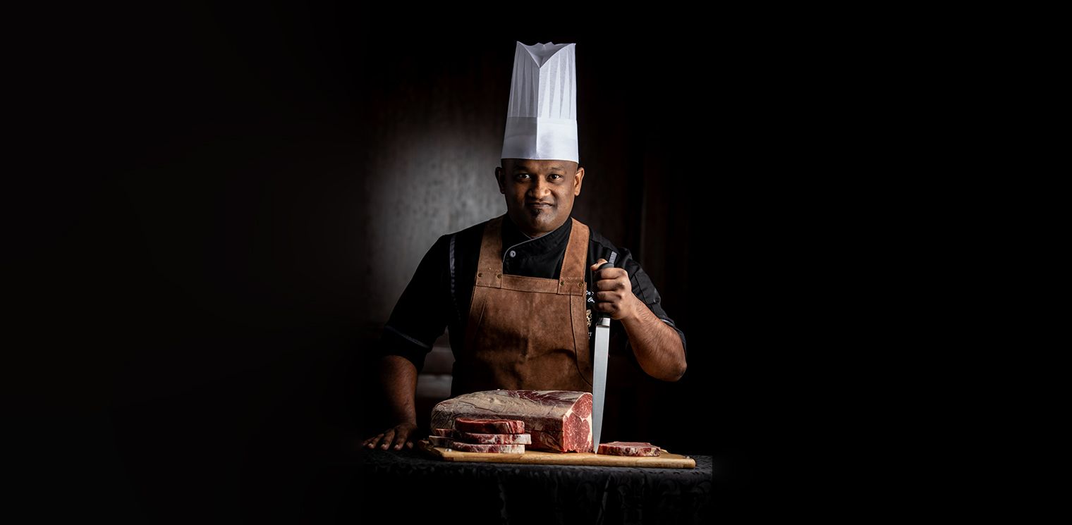 Chef posing with half cut steak at The Kingsbury Hotel