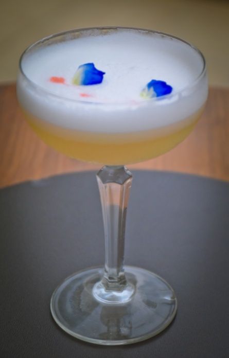 Cocktail drink with blue flower petal garnish at The Kingsbury Hotel