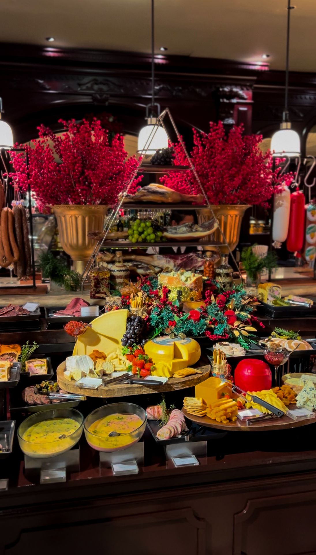 A buffet display with assorted cheeses, charcuterie, grapes, and more