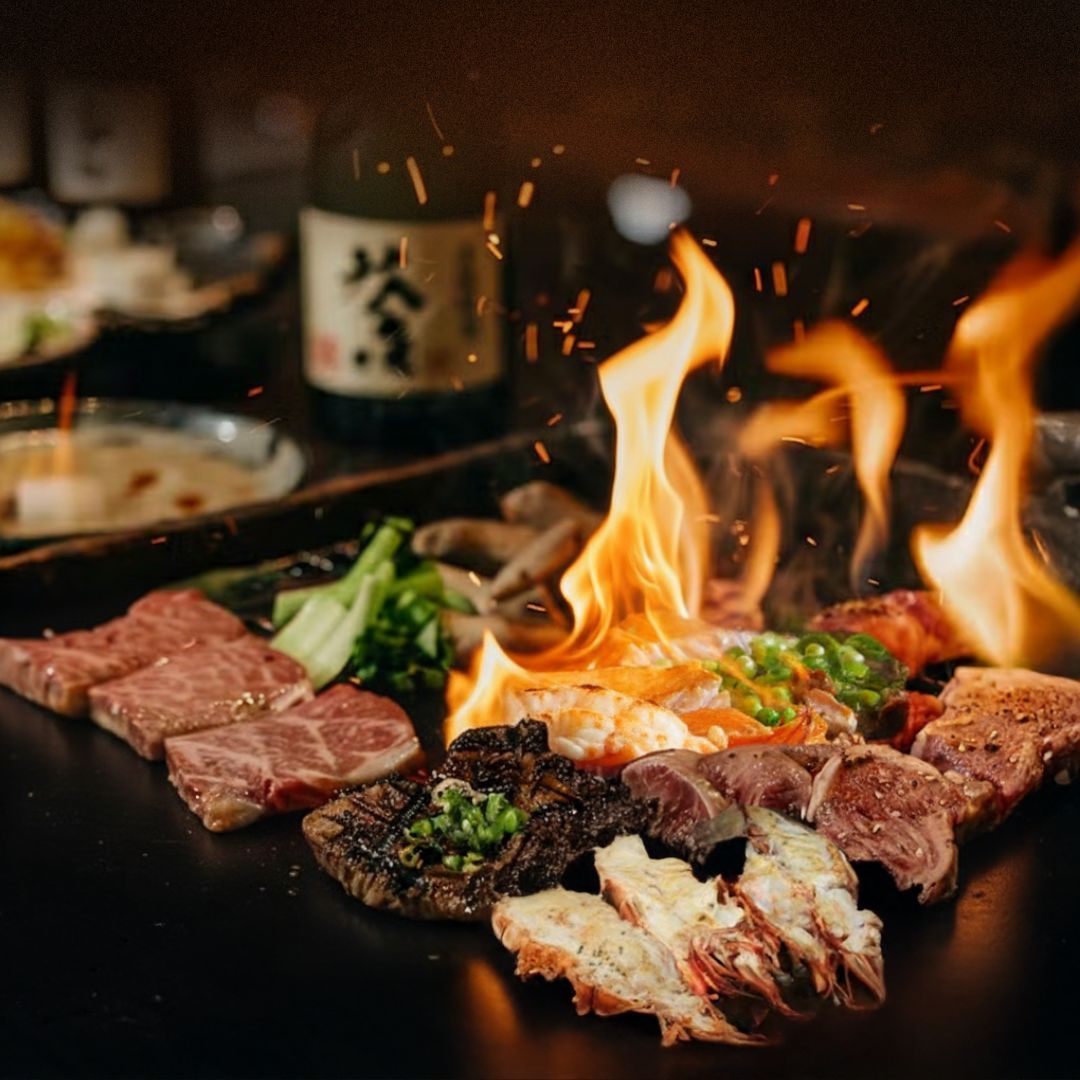 Meats, seafood, and vegetables cooking on a flaming grill