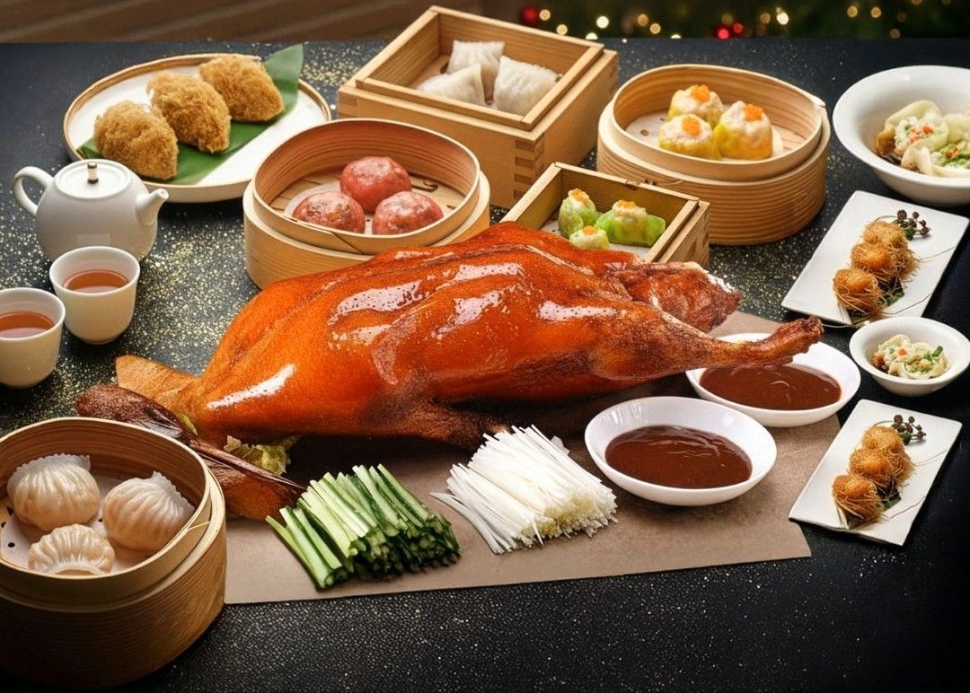 A roasted duck platter with cucumbers, scallions, and dim sum