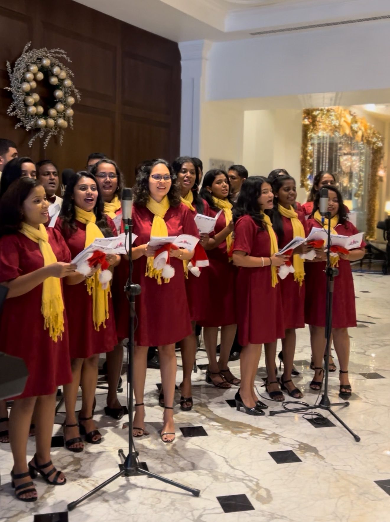 A choir in red and yellow outfits singing inside The Kingsbury Colombo